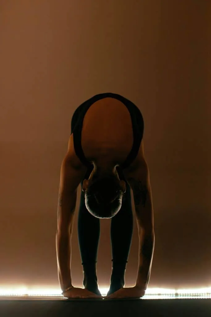 Personne penchée en avant sur un tapis de sport