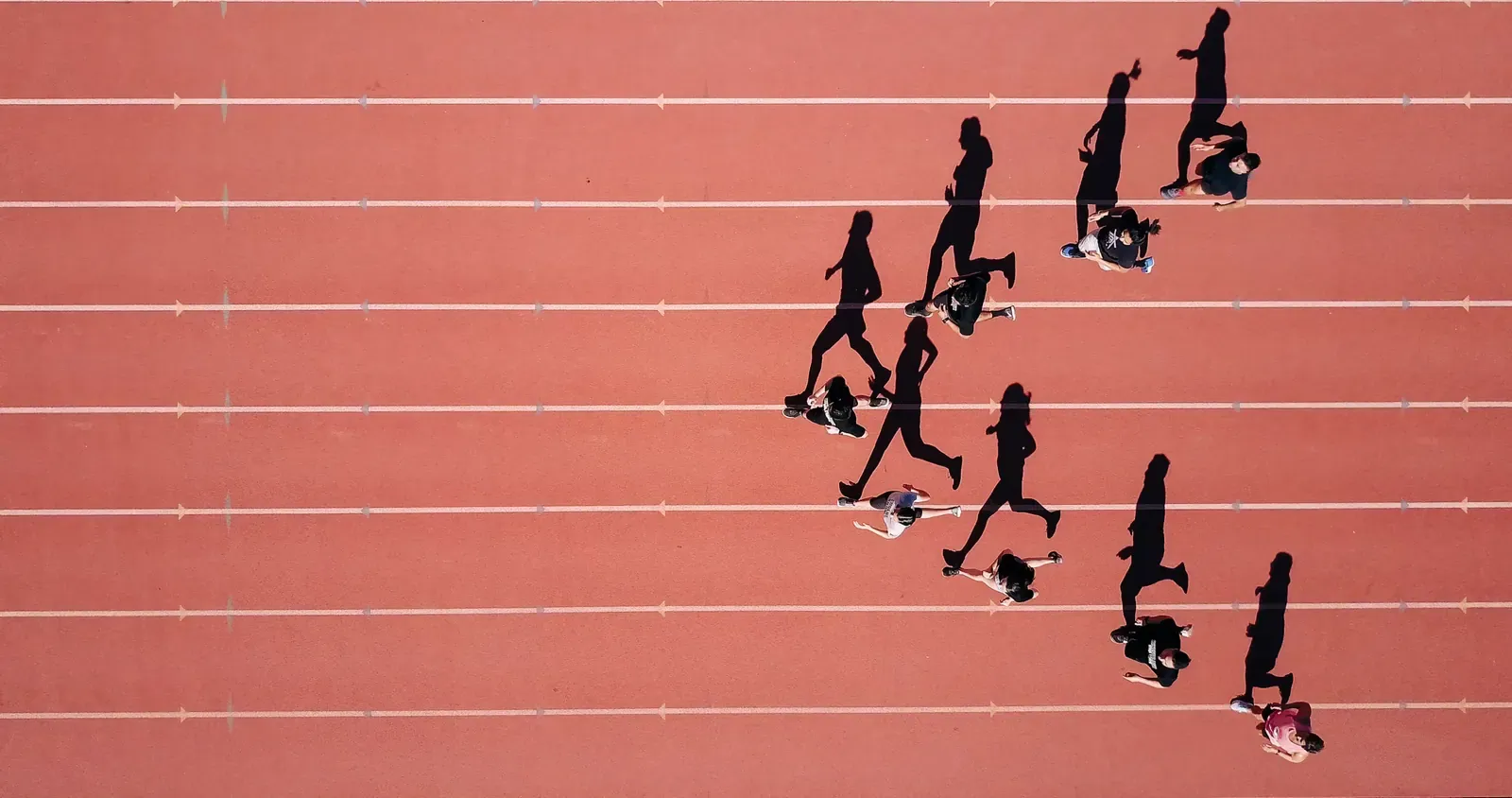 Vue de dessus de coureurs sur une piste, en illustration du retour à l’entraînement après une blessure musculaire