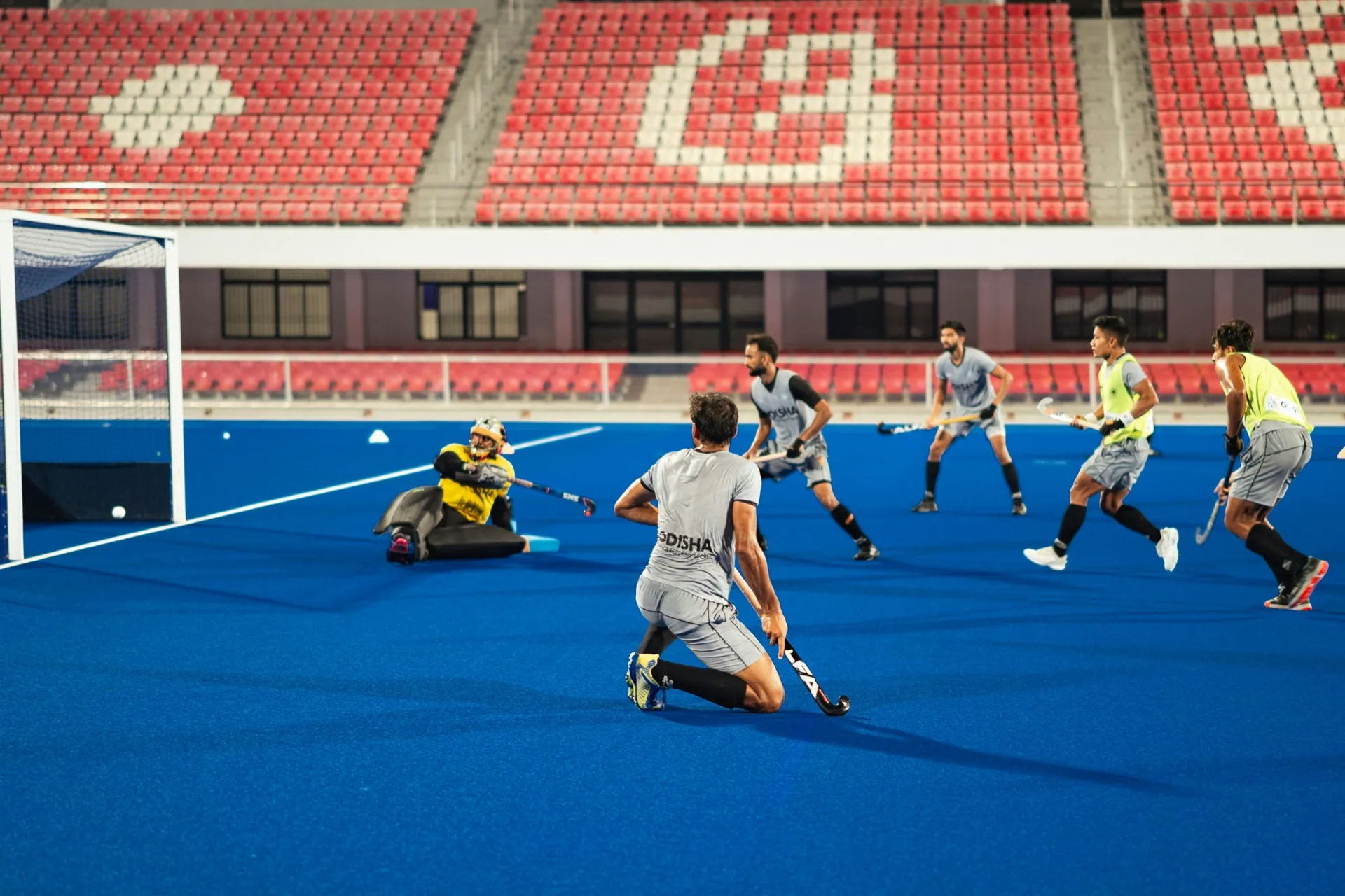 Joueurs de hockey sur gazon sur un terrain bleu