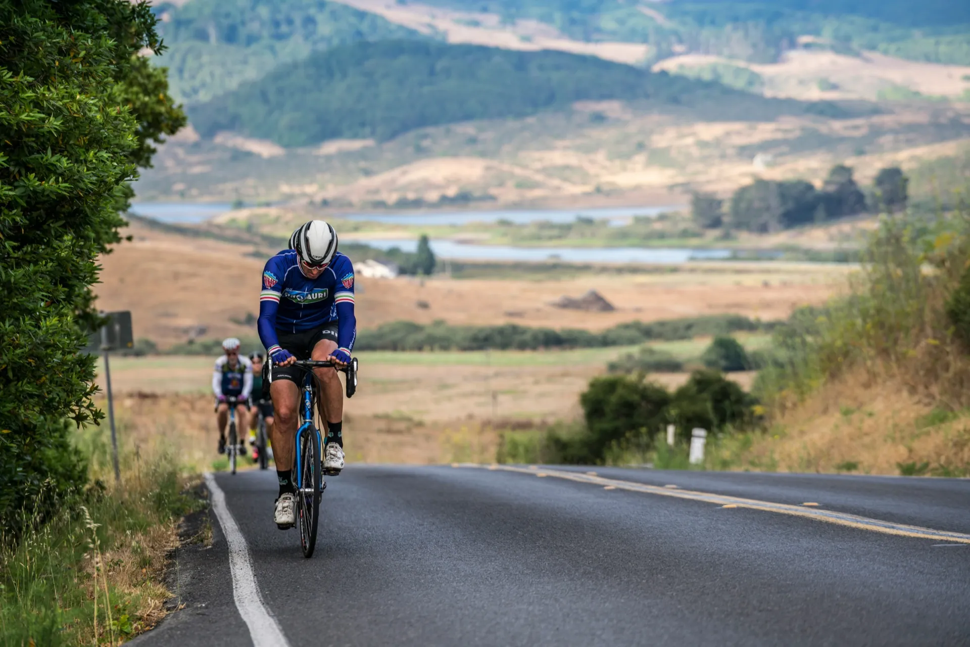 Cycliste sur une route avec deux autres personnes à vélo